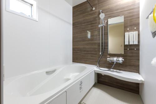 a bathroom with a white tub and a sink at Asobi Stay大日 山吹 in Nagoya