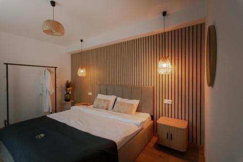 a bedroom with a large white bed with two pillows at Trei Mândre by Cabana CeiTrei in Cozăneşti