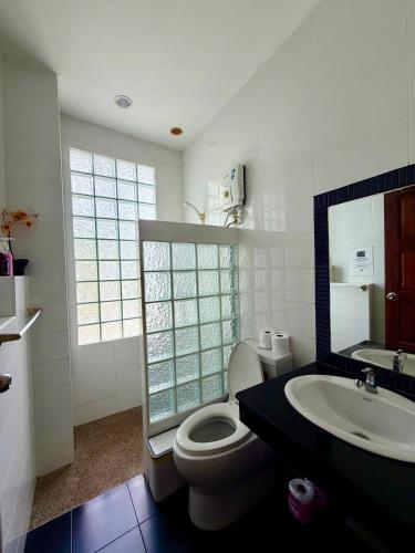 a white bathroom with a toilet and a sink at Viking House Apartment in Ko Tao