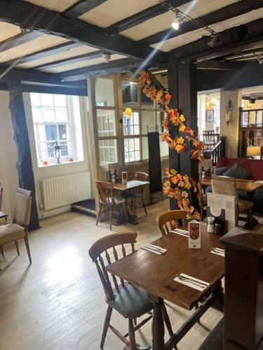 a dining room with a table and chairs and windows at Ye Olde Talbot Hotel by Greene King Inns in Worcester