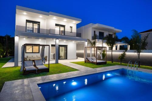 a bedroom villa with a swimming pool at night at Villa Elesia in Kremasti