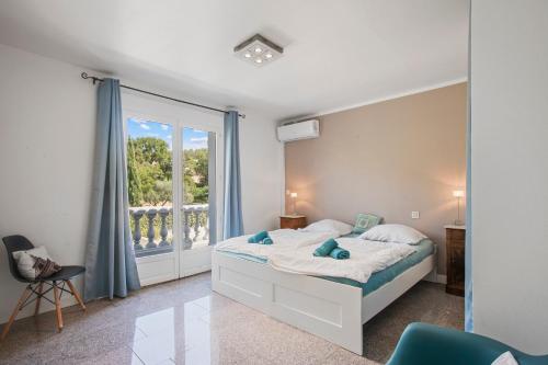 a bedroom with a bed and a large window at Villa Etoile in Cabasse