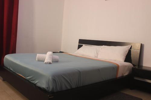 a bedroom with a bed with two towels on it at Astória - Hotel & Suites in Soyo