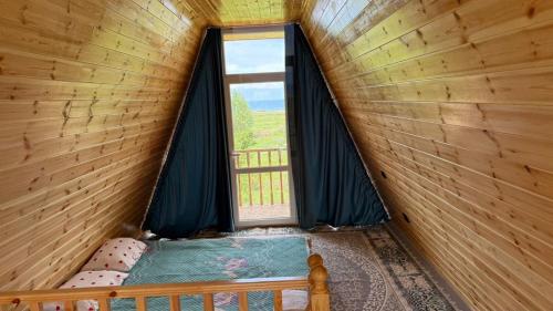 a small room with a bed and a window at JEEK A-Frame in Tong
