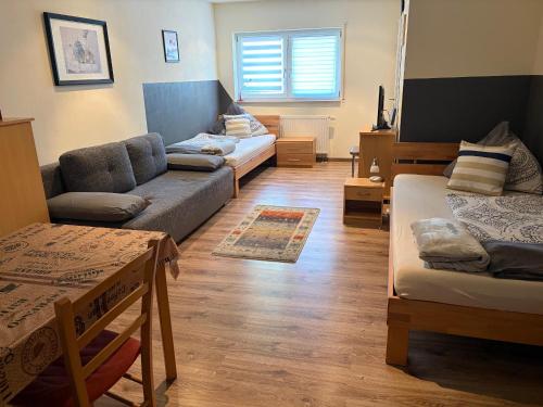 a living room with two beds and a couch and a table at Ferienwohnungen am Main in Erlabrunn