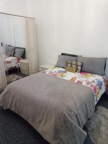 a bedroom with a large bed and a mirror at Beautiful 2 double bedrooms, 2 baths apartment in Port Glasgow
