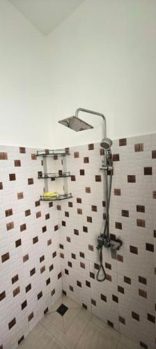a shower in a bathroom with a tile wall at Khmer House Kampot Boutique in Kampot