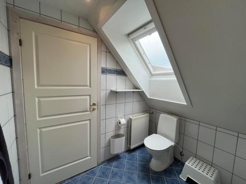 a bathroom with a white toilet and a window at Bed and Breakfast Ringsted Syd in Ringsted