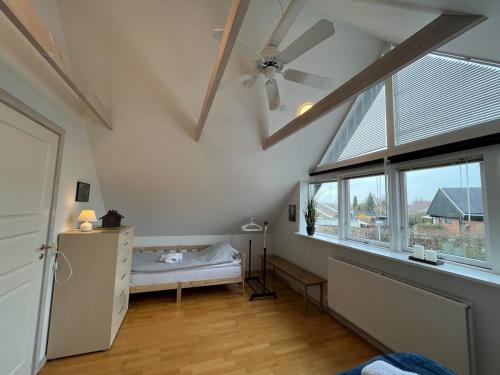 a bedroom with a ceiling fan and a window at Bed and Breakfast Ringsted Syd in Ringsted
