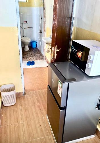 a kitchen with a refrigerator with a microwave on top of it at Tranquil stays in Bungoma