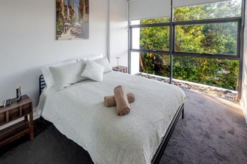 a bedroom with a large bed with a large window at On Flinders Wollongong in Wollongong