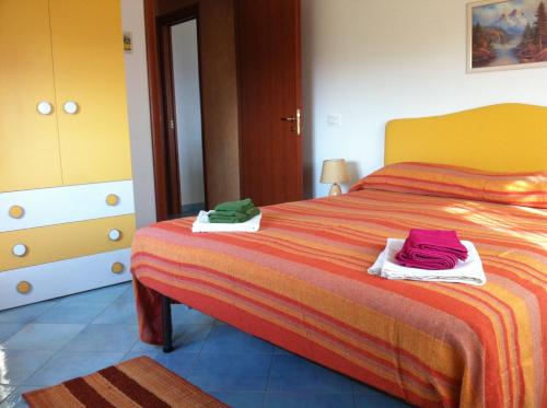 een slaapkamer met een bed met twee handdoeken erop bij Villetta Pergole in Realmonte