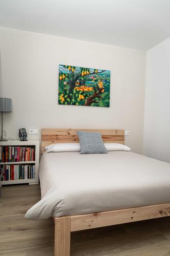 a bedroom with a wooden bed with a painting above it at Piso en Casa de Correos in Molina de Aragón