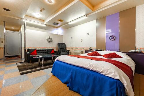 a bedroom with a large bed and a living room at Earn Exception in Isesaki