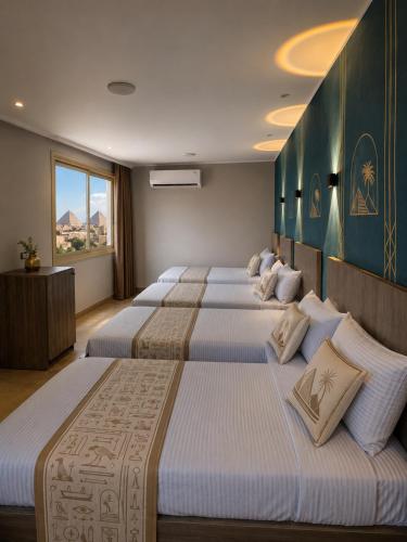 a row of four beds in a hotel room at Red pyramids view hotels in Cairo