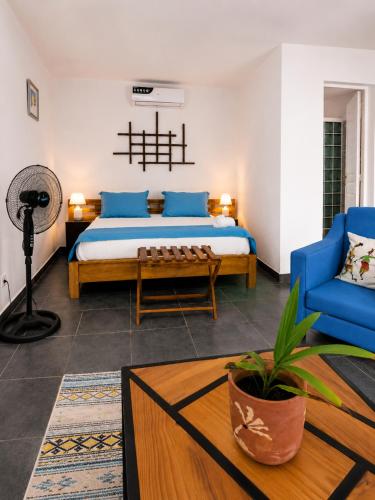 a bedroom with a bed and a blue chair at The Sanctuary MADAGASCAR in Foulpointe