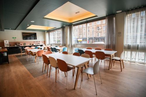a dining room with tables and chairs and windows at Edinburgh Central Accommodation in Edinburgh