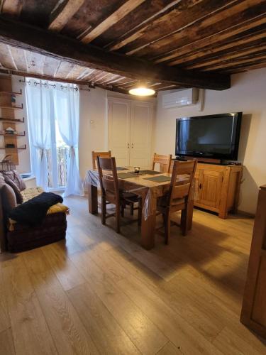 a living room with a table and a tv at The Cozy Collo House in Collobrières