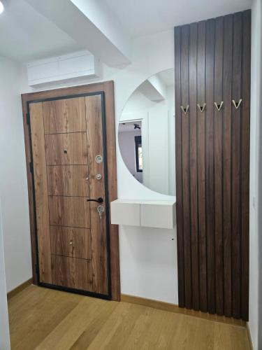 a room with a wooden door and a mirror at Apartman Marija IV in Vrnjačka Banja