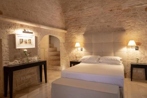 a bedroom with a large bed in a stone wall at Relais Il Santissimo in Turi