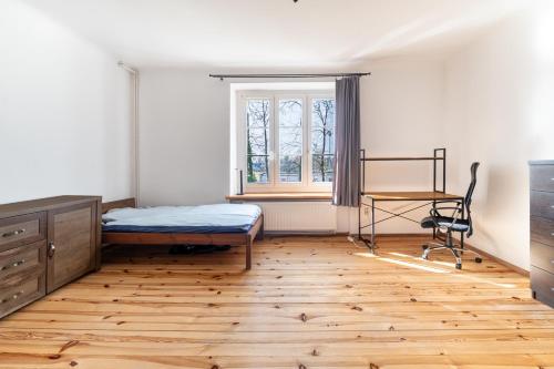 a bedroom with a bed and a desk and a window at Apartament dwupoziomowy in Dęblin