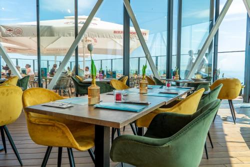 a restaurant with a wooden table and yellow chairs at Punt al Mare in Vlissingen