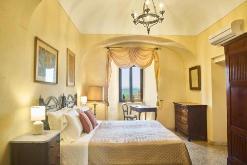 a bedroom with a bed and a desk and a window at Casa Becci Central Large & Sunlit Historical Flat in San Gimignano