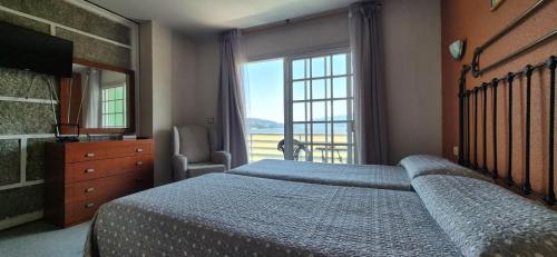 a bedroom with a bed and a large window at Las Islas in Vilaboa