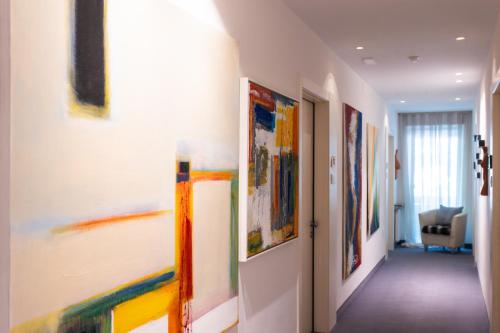a hallway with many paintings on the walls at Pension Martha in Postal
