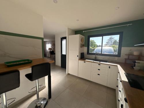 a kitchen with a counter and a sink and a window at Lou Cigalou Clim, jardin privé, parking & Wi-Fi 1 à 4 pers in Avignon
