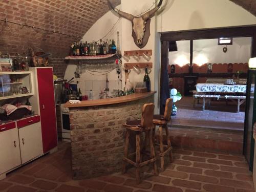 a kitchen with a bar with two wooden stools at Country House Stoljetna Vila in Seona