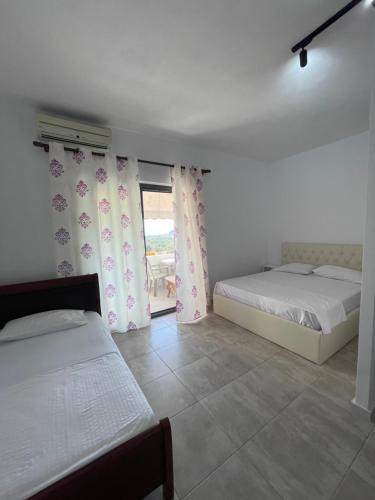 a bedroom with two beds and a window at Aparthotel Borsh in Borsh