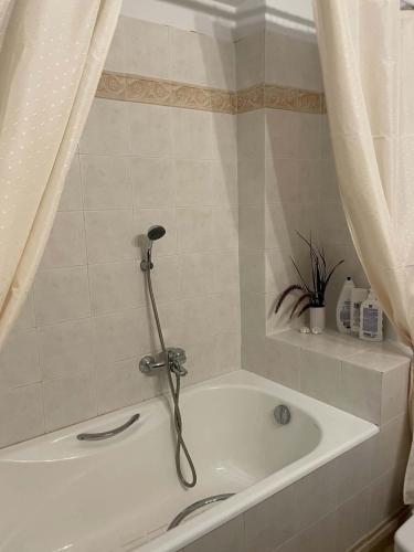 eine Badewanne mit Dusche im Badezimmer in der Unterkunft Aethera Maisonette in Kokóni