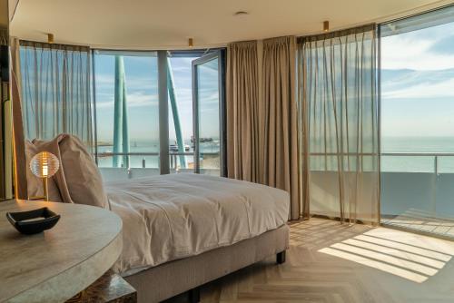 a bedroom with a bed and a view of the ocean at Punt al Mare in Vlissingen