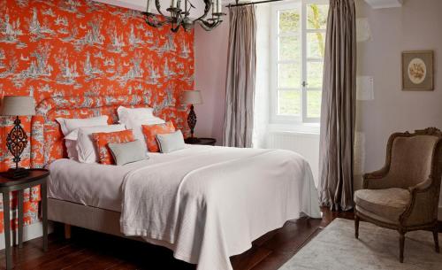 a bedroom with a bed with an orange wall at Villa Privée avec Piscine - Lavy in Saint-Pierre-de-Côle