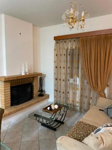 ein Wohnzimmer mit Sofa und Kamin in der Unterkunft Aethera Maisonette in Kokóni