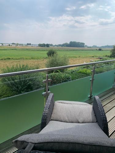 a chair on a balcony with a view of a field at Meer mit Blick, Dat witte Hus in Rettin