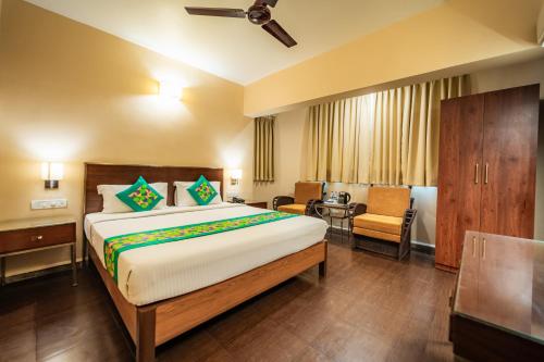 a hotel room with a bed and a chair at Treebo Sunshine Beach Resort with Swimming Pool in Calangute