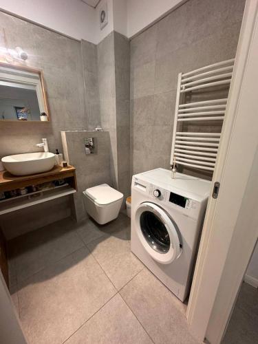 a bathroom with a washing machine and a sink at Two-room apartment in Dudu