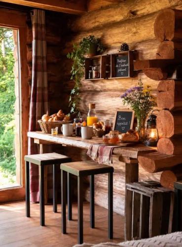 a table with bread and stools in a log cabin at Le nid de bois insolite in Haget