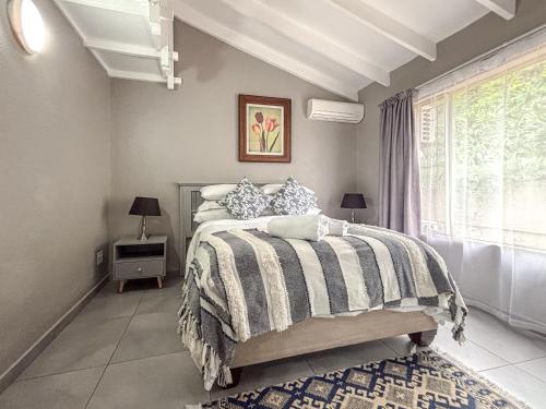 a bedroom with a bed and a window at BondMakers Blue Canoe in Hartbeespoort