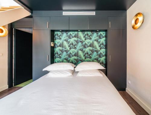 a bedroom with a white bed with a painting on the wall at L' Homillon in Saubion