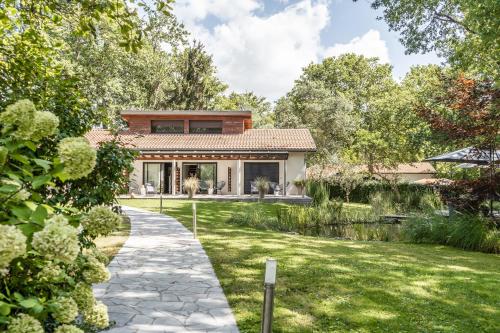 a house with a garden and a walkway at L' Homillon in Saubion
