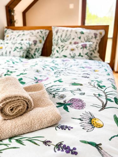 a bed with a blanket and towels on it at Villa Nirvána in Františkovy Lázně