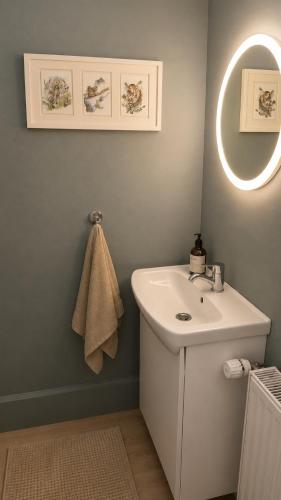 a bathroom with a white sink and a mirror at Grindavik Guesthouse self check in & out in Grindavík
