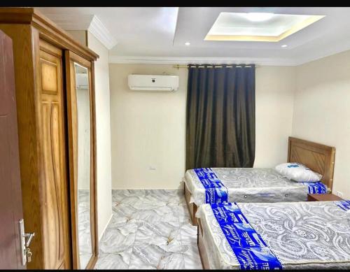 a small bedroom with two beds and a window at الشروق in Al Ḩusānīyah