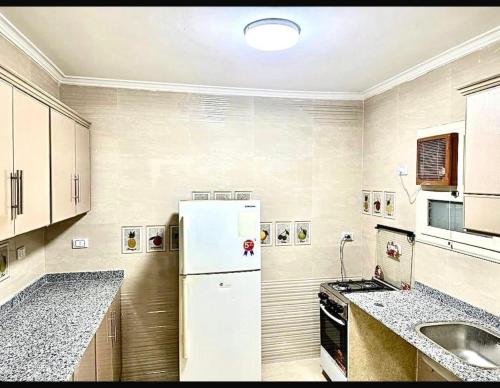 a kitchen with a white refrigerator and a sink at الشروق in Al Ḩusānīyah