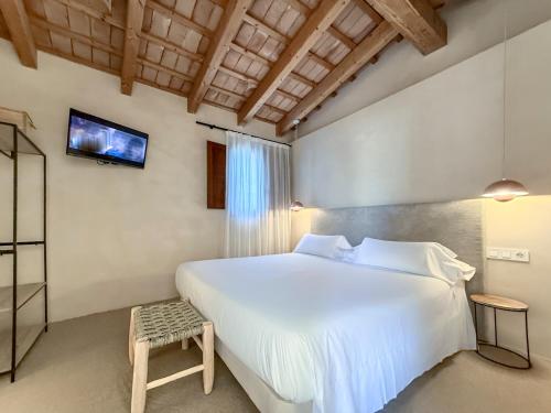 a bedroom with a large white bed and a tv at Boutique Hotel Atelier - Adults only in Sant Pere Pescador