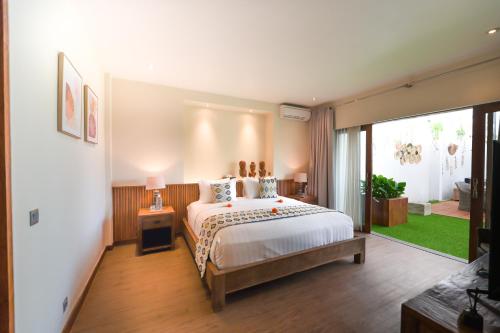 a bedroom with a bed and a large window at Da Vinci The Villa by Nagisa Bali in Tumbak Bayuh