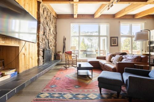 a living room with a couch and a fireplace at Mountainside Top Floor Condo - Treetops Lionshead in Vail